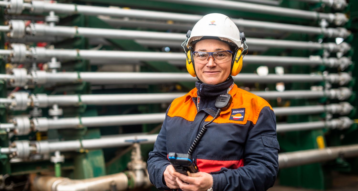 Empleada de repsol con casco de seguridad en la refinería.